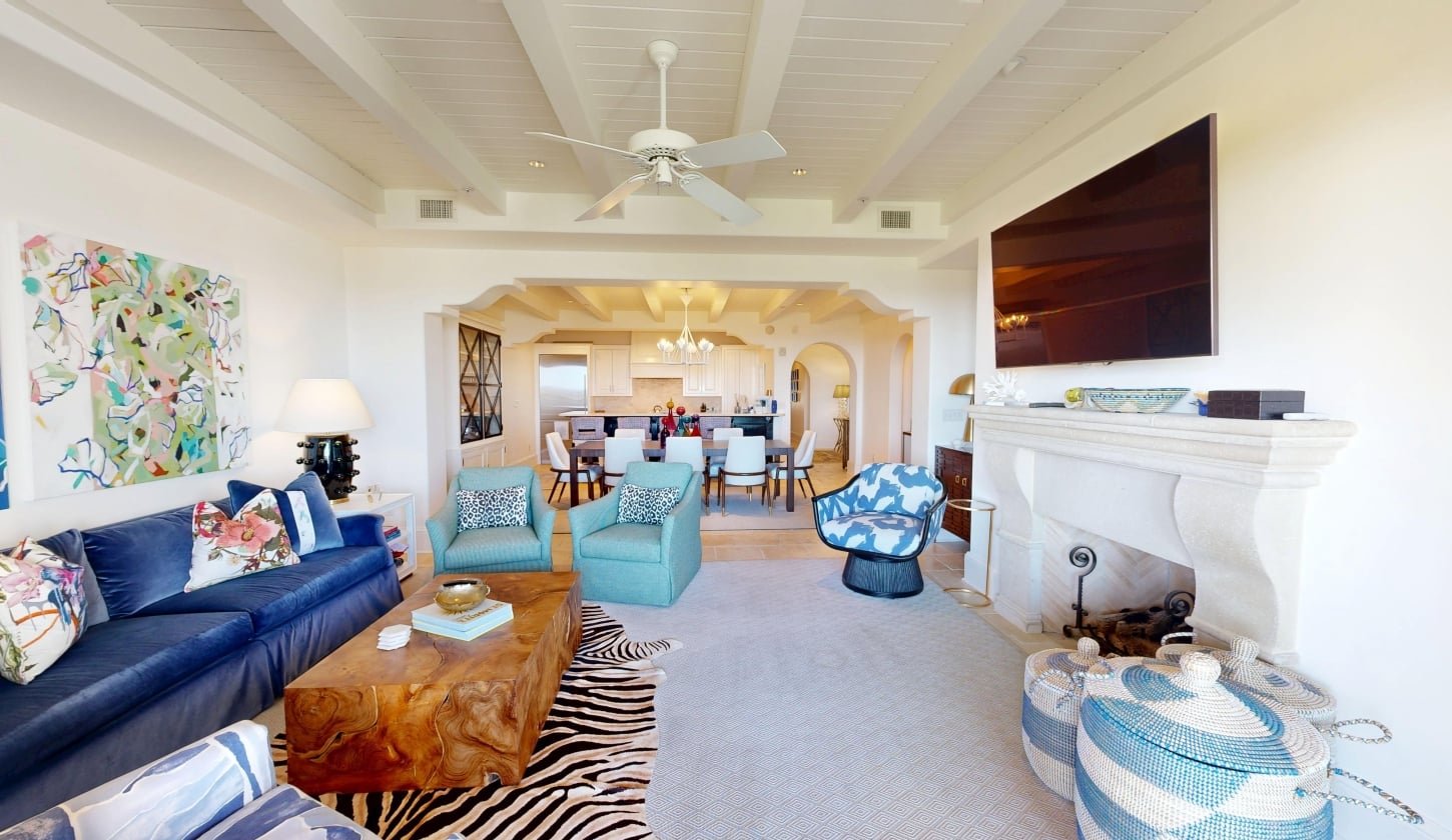 A living room with seating facing a fireplace and television