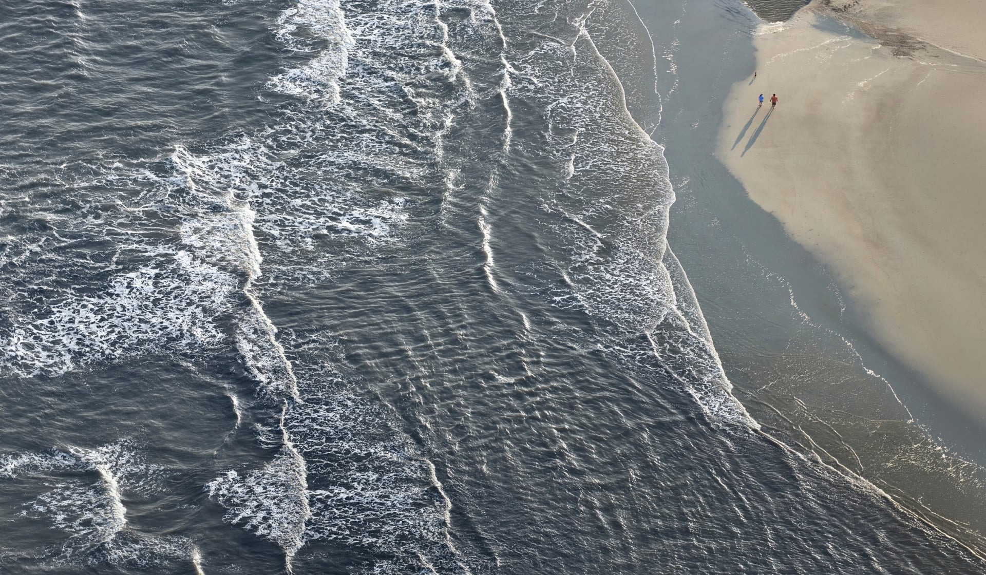 Aerial view of waves and a sandy beach