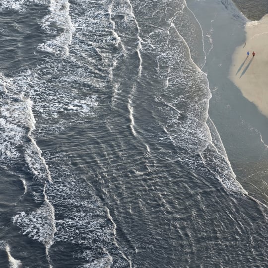 Aerial view of waves and a sandy beach