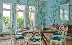 A blue dining room with a circular table and two windows