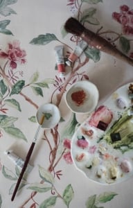 Paintbrushes sit on top of hand-painted wallpapers