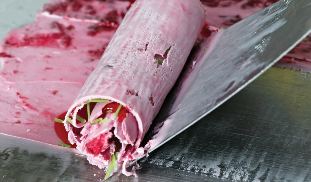 Thai roll ice cream is made by hand on the freezer. Sweet dessert made from natural berries and ingredients. The process of making food.