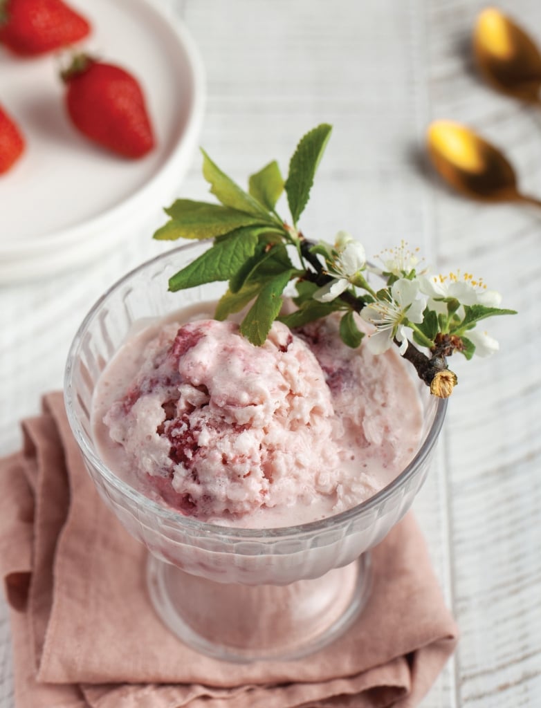 Homemade strawberry ice cream served in an glass bowl, garnished with fresh strawberry slices