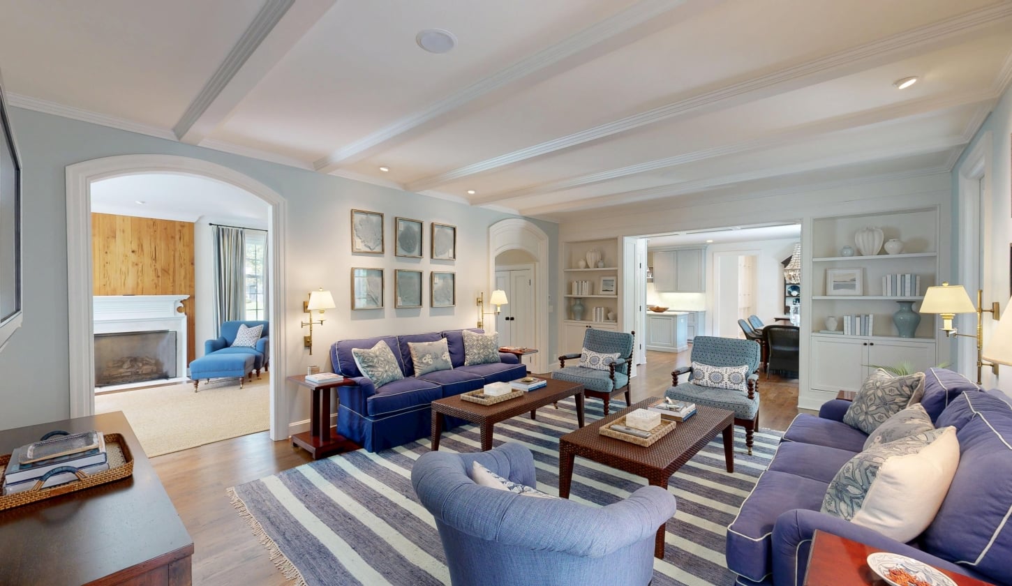 A spacious living room with blue couches and armchairs