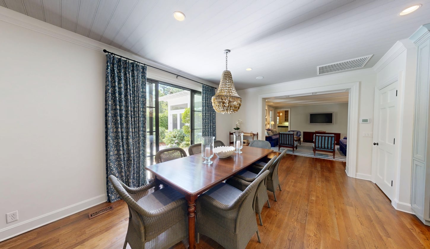 A dining room with glass sliding doors leading to a patio